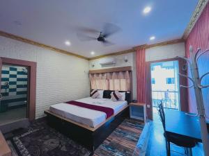 a bedroom with a large bed and a blue table at Hotel Aanandalok in Pānigata