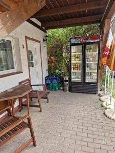 a patio with two wooden benches and a cooler at Pension Assenheim in Assenheim