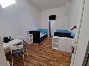 a small room with a bed and a desk and a table at Pension Assenheim in Assenheim +2 photos