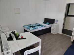 a small room with a desk and a bed at Pension Assenheim in Assenheim