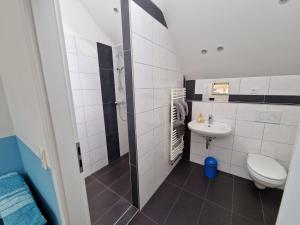 a small bathroom with a toilet and a sink at Pension Assenheim in Assenheim