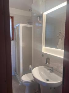 a bathroom with a sink and a toilet and a mirror at Villetta Indipendente Sardegna in Villaputzu +18 photos