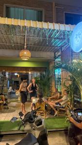 a group of people standing outside of a restaurant at SEVEN Guesthouse in Thong Sala