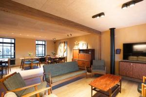 a living room with a couch and chairs and tables at Herberg 't Molenhuis in Vichte