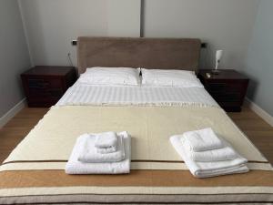 a bed with two towels on it with two pillows at Maya's home Tirana in Tirana