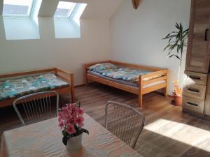 a room with two beds and a table and chairs at Krčma na statku in Zásmuky