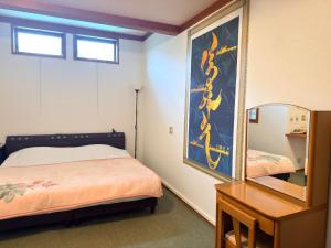 a small bedroom with a bed and a mirror at ペンションminiモンゴル in Makito
