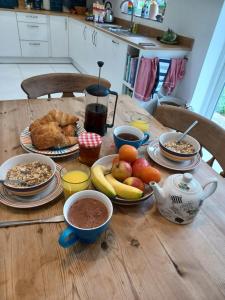 ein Holztisch mit Tellern voller Essen darauf in der Unterkunft Rodali in Lyme Regis + 2 Fotos