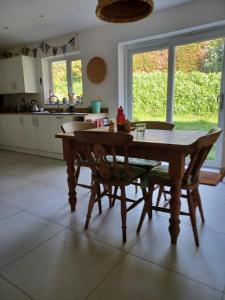 eine Küche mit einem Holztisch und Stühlen in der Unterkunft Rodali in Lyme Regis