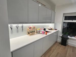 a kitchen with white cabinets and a counter at Modern Townhouse Birmingham in Birmingham