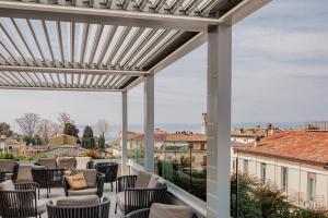 a pergola with chairs and tables on a patio at Solho Hotel in Bardolino
