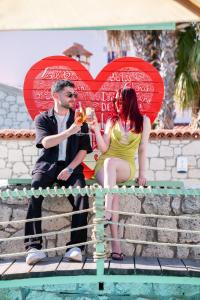 a man and a woman sitting on a ledge with hearts at B House Alaçatı in Alaçatı