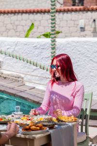 a woman sitting at a table with plates of food at B House Alaçatı in Alaçatı