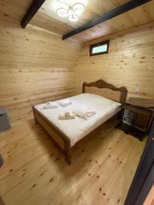 a bedroom with a bed in a wooden room at Makhuntseti Inn in Makhunts'et'i
