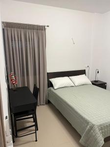 a bedroom with a bed and a table and a window at Nenes Comfort Apartment in Koroni +4 photos