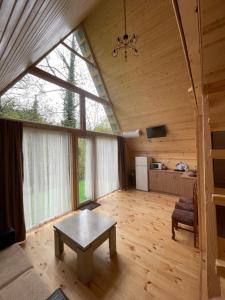a living room with a table in a room with windows at Makhuntseti Inn in Makhunts'et'i