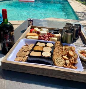 a tray of cheese and crackers and a bottle of wine at Casa de Leon Lakeview Guesthouse in Mississauga