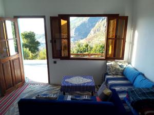 a living room with a blue couch and a window at panorama view in Chefchaouen