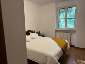 a bedroom with a white bed and a window at Agriturismo Monte Sacro in Mattinata