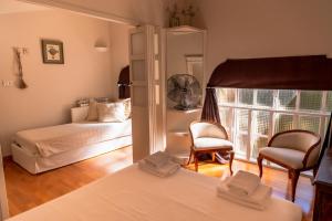 a bedroom with a bed and two chairs and a window at La Limonaia - Tremezzo by LoveComo in Tremezzo +18 photos