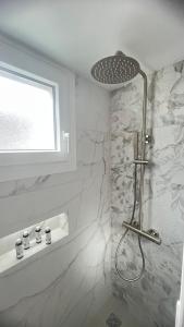 a shower in a bathroom with white walls and a window at VERADA HOUSE in Pera Gyalos