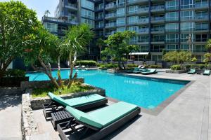 a swimming pool with lounge chairs and a building at Lux SL Luxury Style of Life in Pattaya
