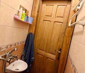 a bathroom with a toilet and a sink and a door at RestMax in Nida