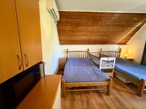 a small room with two beds and a tv at RestMax in Nida