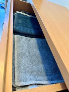 a drawer with blue towels in a wooden drawer at RestMax in Nida +1 photo