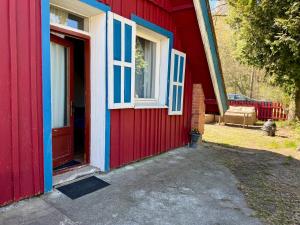 a red house with blue and white doors and a window at RestMax in Nida