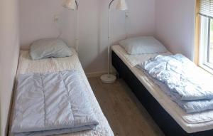 two twin beds in a room with a window at Nice Apartment In Farsø With Heated Swimming Pool in Farsø +5 photos
