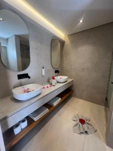 a bathroom with two sinks and a large mirror at Al Jazira Beach & Spa- All Inclusive - Families and Couples Only in Houmt Souk