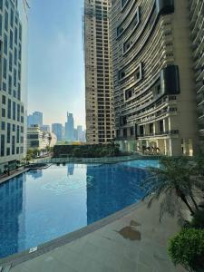 a large swimming pool in a city with tall buildings at Knightsbridge Residences in Manila