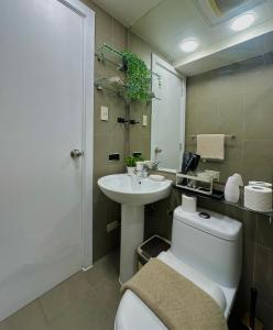 a bathroom with a toilet and a sink at Knightsbridge Residences in Manila +6 photos