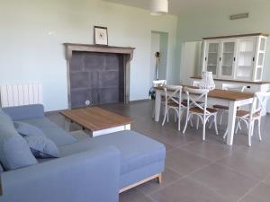 a living room with a couch and a table and chairs at Le Gite des Sources in Lormes