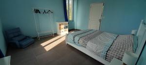 a blue bedroom with a bed and a chair at Le Gite des Sources in Lormes