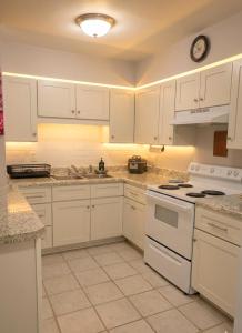 a kitchen with white cabinets and white appliances at Tiny Palace - 1-Bedroom Apartment - Multi-Week Stay - Pool - Washer-Dryer - Dog-friendly with fee for 1 Family Pet in Wilmington