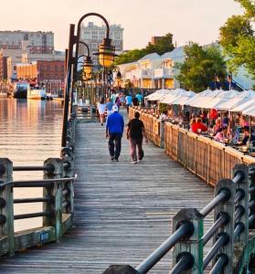 people walking down a wooden pier next to the water at Tiny Palace - 1-Bedroom Apartment - Multi-Week Stay - Pool - Washer-Dryer - Dog-friendly with fee for 1 Family Pet in Wilmington