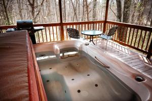 a hot tub on a deck with a table and chairs at Cardinal's Crest in Logan