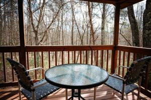 a glass table and two chairs on a porch at Cardinal's Crest in Logan +16 photos