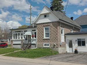 a brick house with a porch on a street at Guest Suite in Smiths Falls