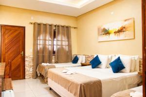 a hotel room with two beds and a door at Pousada Jagatá in Tutóia