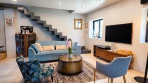 a living room with a blue couch and a tv at Lis Oureto in Saint-Cyr-sur-Mer