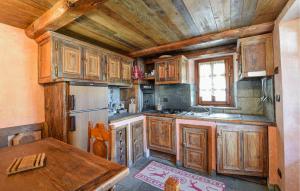 a kitchen with wooden cabinets and a wooden table at Amazing Apartment In Cogne in Cogne
