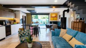 a living room with a blue couch and a kitchen at Lis Oureto in Saint-Cyr-sur-Mer