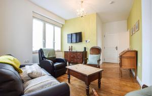a living room with a couch and chairs and a table at Agréable Jardin Et Terrasse in Sourdeval