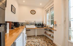 a kitchen with a counter and a clock on the wall at Agréable Jardin Et Terrasse in Sourdeval