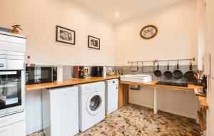 a kitchen with a washing machine and a washer at Agréable Jardin Et Terrasse in Sourdeval
