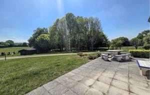 a picnic table and benches in a park at Gite En Campagne in Avezé