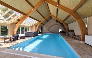 an indoor swimming pool with a ceiling with windows at Gite En Campagne in Avezé +9 photos